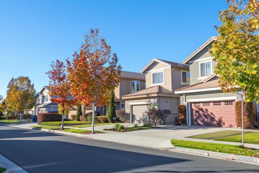 Residential street with houses and autumn trees, showcasing suburban living, relevant to tax planning and investment strategies.
